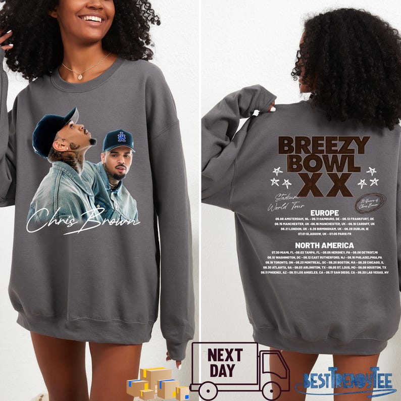 May include: A gray sweatshirt featuring a graphic of Chris Brown on the front. The back of the sweatshirt displays "Breezy Bowl XX" tour details, including European and North American tour dates. The sweatshirt is a unisex garment.