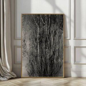 May include: Black and white framed art print featuring a close-up of a tree trunk and branches. The artwork is displayed in a gold frame and leans against a white wall with decorative molding. The image has a natural, organic theme.