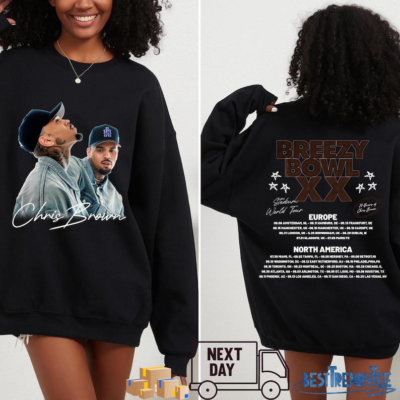 May include: Black sweatshirt featuring a Chris Brown image on the front and a tour graphic on the back. The front displays a photo of Chris Brown with his signature. The back lists tour dates for Europe and North America.