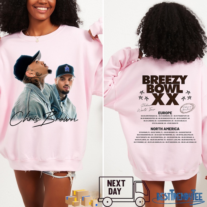 May include: A light pink sweatshirt featuring a graphic of Chris Brown on the front. The back of the sweatshirt displays "Breezy Bowl XX World Tour" text and a list of tour dates in Europe and North America.