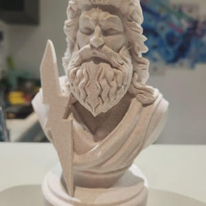Peut inclure: Buste beige clair de Zeus, dieu grec, tenant un éclair. La sculpture présente des traits de visage détaillés, dont une longue barbe et des cheveux fluides. Le buste est monté sur une base circulaire.