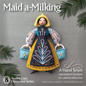May include: A felt ornament depicting a woman in a yellow dress and blue and white apron, holding two buckets. The ornament is part of a Twelve Days of Christmas series, with the number 8 on the bottom left corner. The text "Maid a-Milking" is at the top of the image. The ornament is a hand-sewn pattern by Larissa Holland.