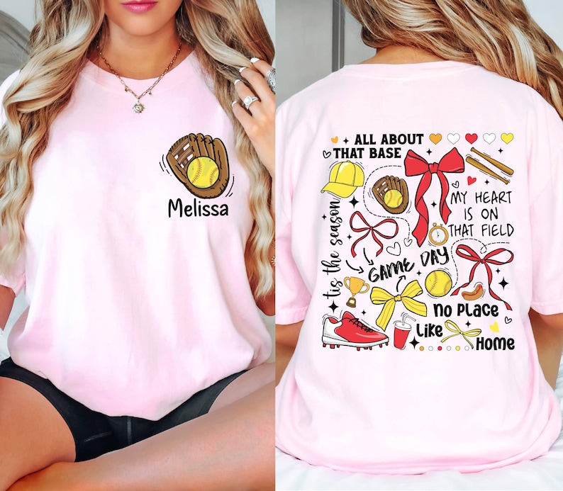 May include: Pink t-shirt with a softball and glove graphic on the front and a design with the text "All About That Base", "Tis the Season", "Game Day", "My Heart is on That Field", "No Place Like Home" on the back.