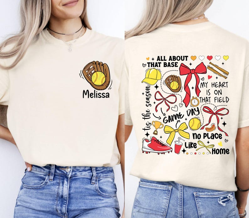 May include: A cream-colored t-shirt with a softball-themed design. The front of the shirt has a cartoon image of a glove catching a softball. The back of the shirt has a variety of softball-related images, including a baseball cap, a glove, a trophy, a drink, a bow, and a baseball. The text on the back of the shirt reads "All About That Base", "Tis The Season", "Game Day", "My Heart Is On That Field", "No Place Like Home".