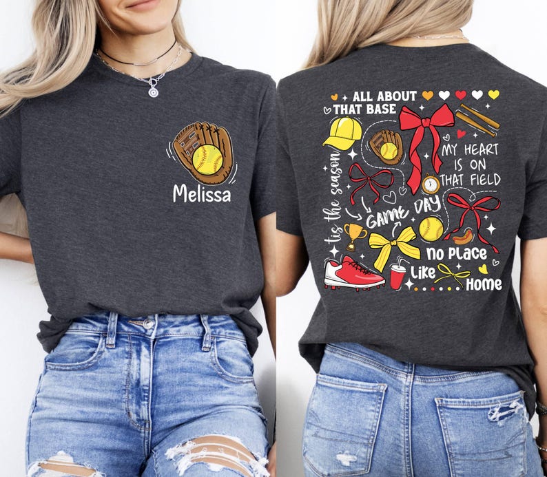 May include: Two gray t-shirts with a baseball theme. One shirt has a baseball glove and ball with the name "Melissa" on it. The other shirt has a variety of baseball-themed graphics, including a baseball glove, a baseball, a trophy, a bow, and the text "All About That Base", "My Heart Is On That Field", "Game Day", "No Place Like Home", and "Tis The Season".