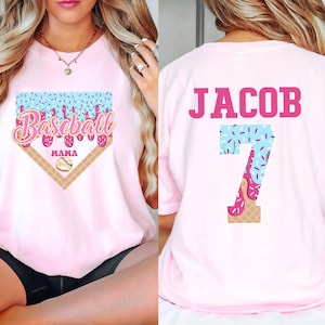 May include: Two pink t-shirts with a baseball theme. One shirt says "Baseball Mama" with a baseball diamond and a melting ice cream cone. The other shirt says "Jacob" with the number "7" in the same ice cream cone design.