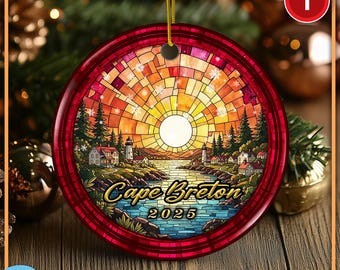 Könnte beinhalten: Ein rundes Keramikornament mit einer Illustration im Buntglas-Stil, die eine Küstenlandschaft mit Leuchtturm, Häusern und Sonnenuntergang zeigt. Der Text Cape Breton 2025 ist mittig aufgedruckt. Es hängt an einer goldenen Schnur.