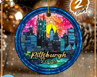 May include: A round Christmas ornament featuring a stained glass style depiction of the Pittsburgh skyline at sunset. The ornament is blue with a gold inscription that reads "Pittsburgh 2025".