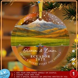 May include: A circular glass Christmas bauble featuring a landscape painting of a mountain and fields. The bauble has the text "Olivia & Liam ECUADOR 2025 Family Makes Every Day Shine."
