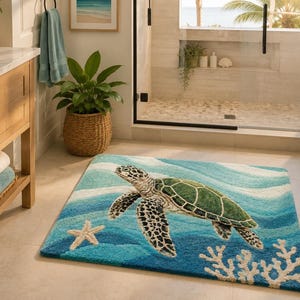 May include: A rectangular bath mat featuring a sea turtle design. The mat has a blue and white wave pattern with a green and black sea turtle, a white starfish, and coral accents. The mat is placed in a bathroom.