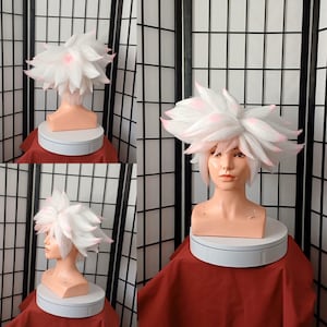May include: White wig with pink highlights styled in a spiky, choppy fashion. The wig is on a mannequin head.