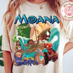 Puede incluir: Una camiseta blanca con un estampado gr&aacute;fico colorido de personajes de la pel&iacute;cula de Disney Moana. El gr&aacute;fico incluye a Moana, Maui, el semidi&oacute;s, y el oc&eacute;ano.