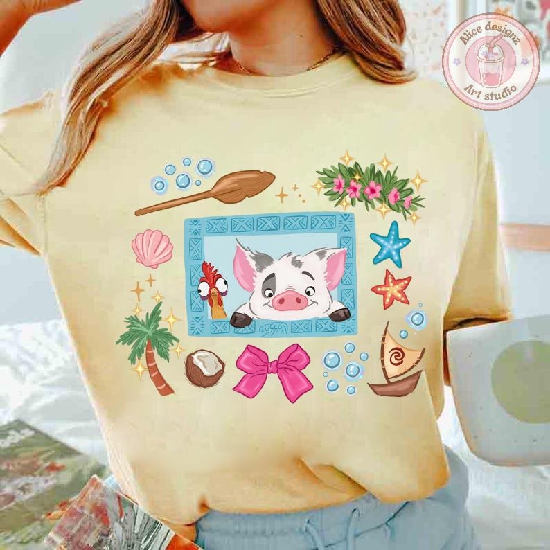 Puede incluir: Camiseta amarilla clara con una ilustraci&oacute;n de dibujos animados que presenta un cerdo, un pollo y elementos tropicales. El dise&ntilde;o incluye un lazo rosa, conchas marinas y un peque&ntilde;o barco. La camiseta tiene un corte holgado.