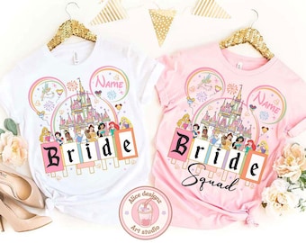 May include: White and pink t-shirts with a Disney princess theme. The white shirt says "Bride" and the pink shirt says "Bride Squad". Both shirts feature a castle, rainbow, and princess graphics.