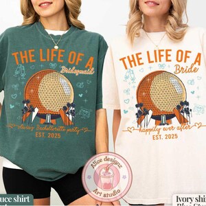 May include: Two oversized t-shirts, one spruce green and one ivory, featuring a graphic of a geodesic sphere with text. The green shirt reads "THE LIFE OF A Bridesmaid" and the ivory shirt reads "THE LIFE OF A Bride". Both shirts say "EST. 2025".