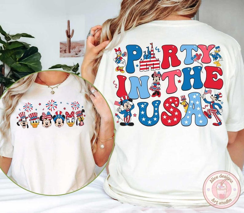 Peut inclure: T-shirt blanc cass&eacute; avec un motif graphique color&eacute;. Le devant pr&eacute;sente des personnages de dessins anim&eacute;s avec des chapeaux patriotiques et des feux d'artifice. Le dos du t-shirt dit "Party in the USA" en lettres rouges et bleues.