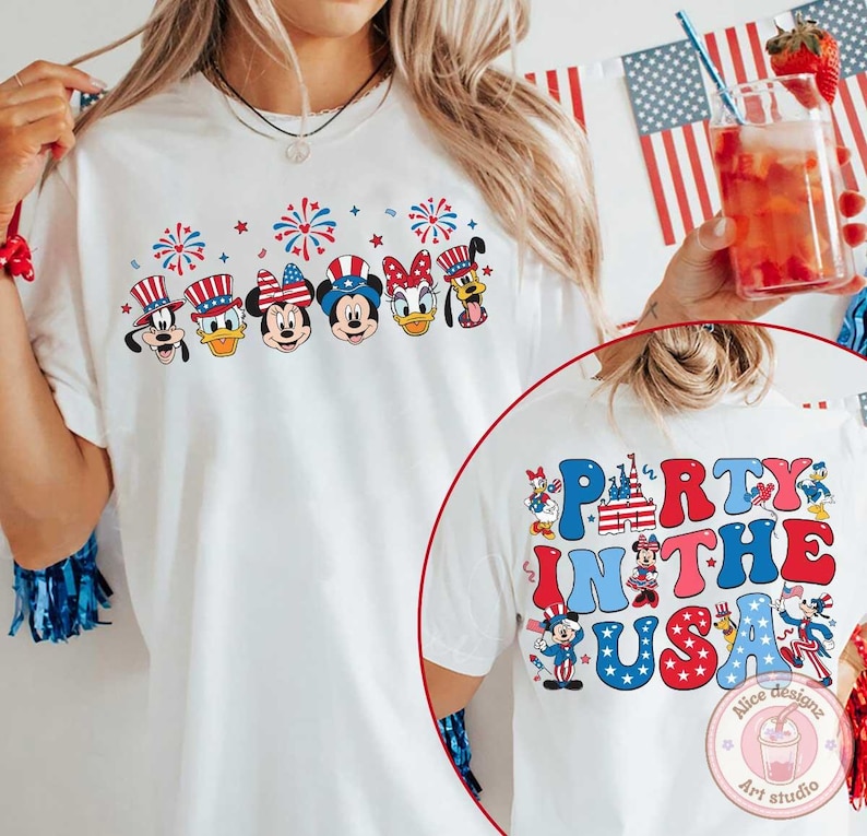 Peut inclure: T-shirt blanc avec un motif color&eacute; de personnages Disney portant des chapeaux patriotiques et des feux d'artifice. Le dos du t-shirt affiche le texte "Party in the USA" avec des illustrations de personnages Disney. Un design festif.