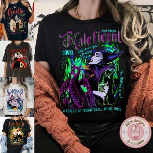 May include: Black t-shirt with a graphic print of Maleficent from the Disney movie Sleeping Beauty. The graphic includes a dragon, the text "Maleficent", "Evil Magic", "The Mistress of Evil", "1959", and "A forest of thorns shall be his tomb".