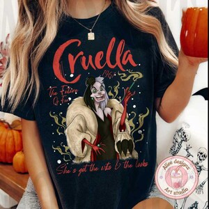 May include: Black t-shirt with a graphic of Cruella De Vil from the Disney movie 101 Dalmatians. The text "Cruella 1961" is above the image. The text "The Future Of Fur" is below the image. The text "She's got the wits & the looks" is at the bottom of the image.