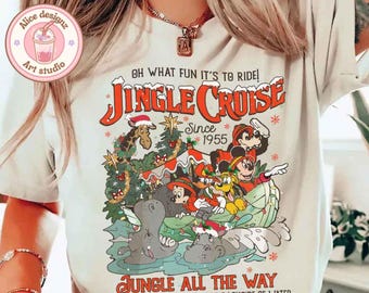 May include: A white t-shirt with a vintage-style graphic of Mickey Mouse and friends on a jungle cruise boat. The text reads "Oh what fun it's to ride! Jingle Cruise Since 1955 Jungle All The Way Eighth Wonder of the World Backside of Water."