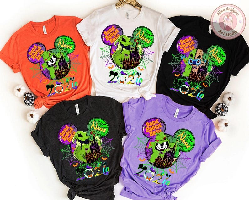 May include: Five colorful t-shirts with Halloween-themed designs. Each shirt features a Mickey Mouse head with a character, the words "Boogie Bash", and the year "2020". The shirts are orange, white, black, dark gray, and purple.