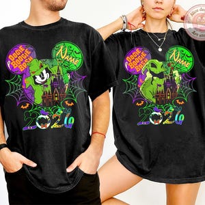 May include: Black t-shirts with a colorful graphic design featuring a green character, a haunted castle, and the text "Oogie Boogie Bash" and "2020". The design is set within Mickey Mouse ears.