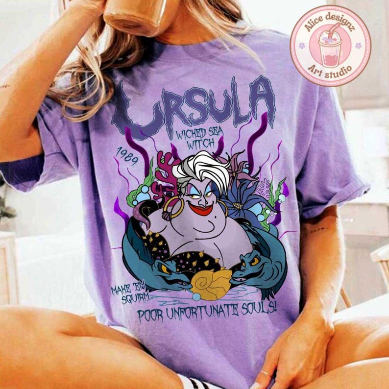 May include: Purple t-shirt with a graphic of Ursula from The Little Mermaid. The graphic includes the text "Ursula, Wicked Sea Witch, 1989, Make 'em Squirm, Poor Unfortunate Souls!"