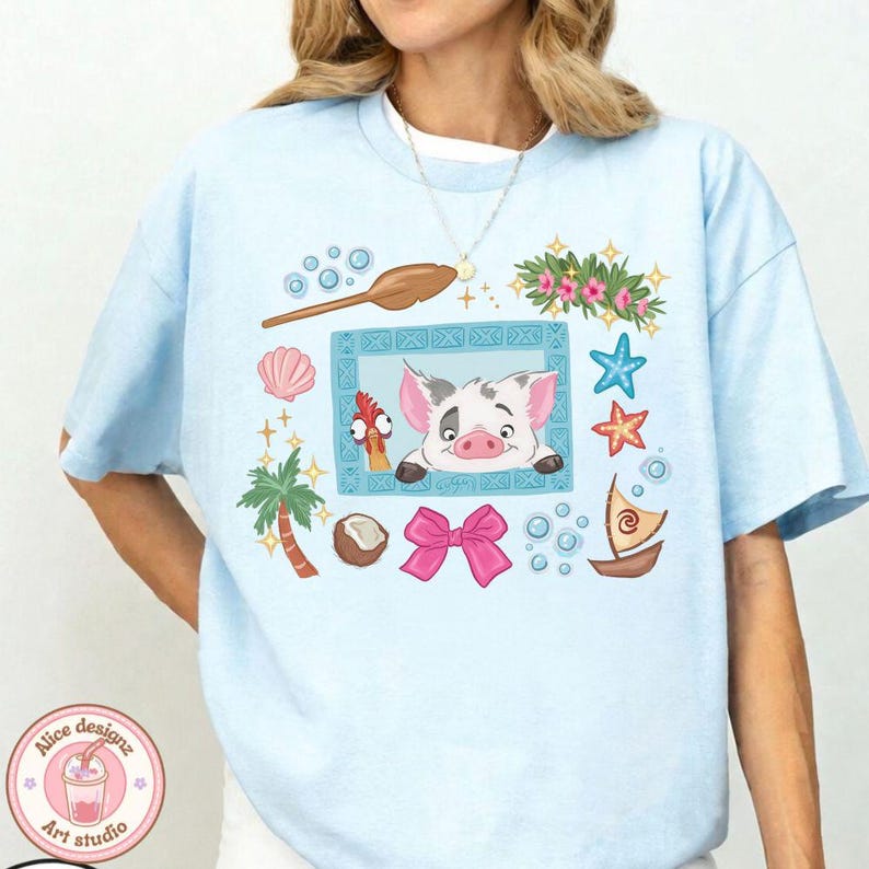 Puede incluir: Camiseta azul claro con una ilustraci&oacute;n de dibujos animados que presenta un cerdo, un gallo y elementos tropicales. El dise&ntilde;o incluye un lazo rosa, una concha, una palmera y un peque&ntilde;o barco. La camiseta tiene cuello redondo y mangas cortas.