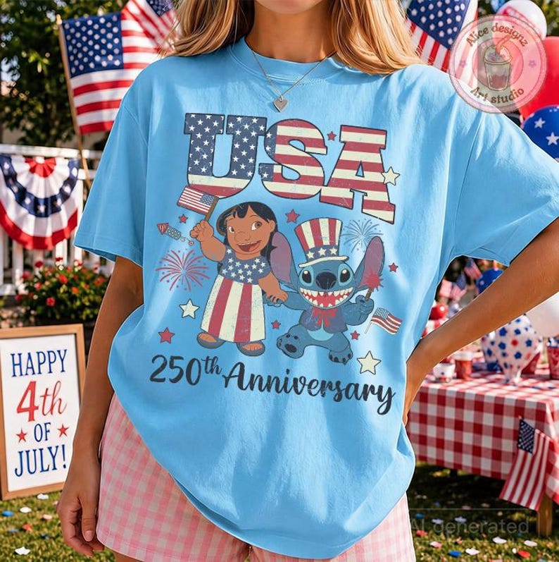 May include: A light blue t-shirt featuring a graphic of Lilo and Stitch wearing patriotic clothing. The design includes the text USA and 250th Anniversary, along with American flag patterns, stars, and fireworks. The shirt has a crew neckline.