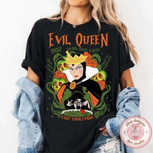 May include: Black t-shirt with a graphic of the Evil Queen from Snow White. The graphic features the Evil Queen holding a cauldron and surrounded by skulls and roses. The text "Evil Queen 1957 Go On. Have a Bite" is printed above the graphic. The text "Don't be frightened" is printed to the right of the graphic. The text "Once upon a time" is printed to the left of the graphic. The text "Cast Your Curse" is printed below the graphic.