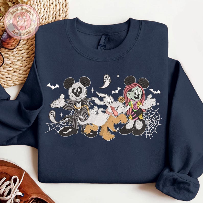 May include: Navy blue sweatshirt featuring a Halloween-themed graphic. The design includes Mickey Mouse as Jack Skellington, Goofy as a ghost, and Minnie Mouse as a Frankenstein-inspired character, along with bats, ghosts, and spiderwebs.