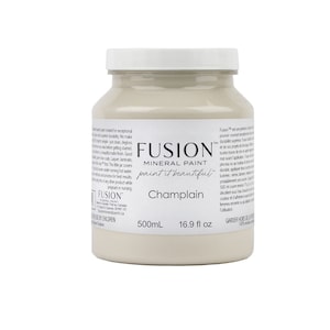May include: A 16.9 fluid ounce bottle of Fusion Mineral Paint in the color Champlain. The bottle is white with a beige label that says "Fusion Mineral Paint paint it beautiful Champlain 500mL 16.9 fl oz".