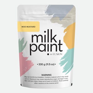 May include: A white pouch of "milk paint" by Fusion, with the color "Mod Mustard" indicated on a yellow label. The package contains 330 g (11.5 oz) of paint. The design includes colorful brushstroke accents in blue, yellow, pink, and gray.