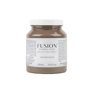 May include: A 16.9 fluid ounce bottle of Fusion Mineral Paint in the color Wood Wick. The paint is a light brown color and is labeled with the Fusion logo and the name of the color.