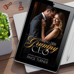 May include: A black tablet displays the cover of "Taming Her Grumpy CEO" by Paige Turner. The cover features a couple embracing. The title is in gold script. A white stylus and office supplies are on the wooden desk.