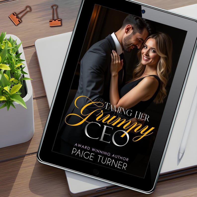 May include: A black tablet displays the cover of "Taming Her Grumpy CEO" by Paige Turner. The cover features a couple embracing. The title is in gold script. A white stylus and office supplies are on the wooden desk.