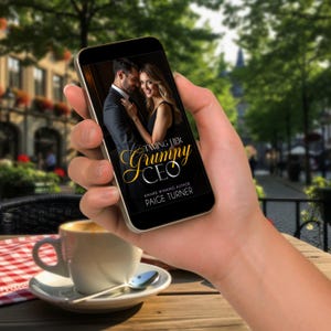 May include: A smartphone displays the cover of "Taming Her Grumpy CEO" by Paige Turner. The book cover features a couple embracing. A cup of coffee sits on a saucer with a spoon on a table with a red and white checkered tablecloth.