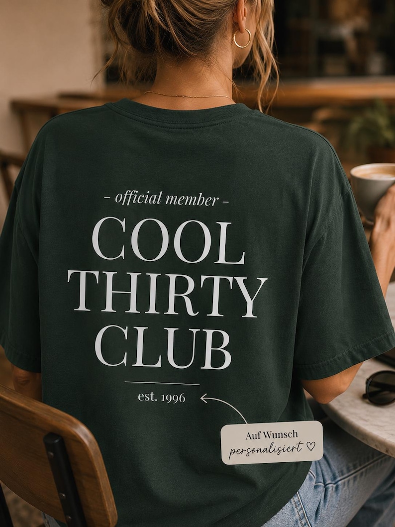 May include: A dark green short-sleeved t-shirt featuring white text on the back that reads - official member - COOL THIRTY CLUB and est. 1996. A small rectangular graphic with an arrow points to the text with the words Auf Wunsch personalisiert.