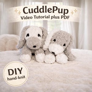 Peut inclure: Deux jouets en forme de chien, gris et blanc, avec des oreilles tombantes et des yeux noirs, sont placés côte à côte sur une surface blanche et moelleuse. Le texte "CuddlePup Video Tutorial plus PDF" est au-dessus des chiens. Une étiquette circulaire indique "DIY hand-knit."