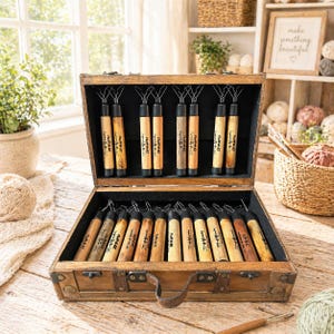 May include: A wooden carrying case containing a collection of metal-tipped crafting tools with wooden handles. The tools are arranged in rows, with some secured in the lid and others in the base. Each handle is labeled with the text Fluff-N-EZ.