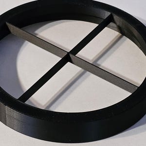 May include: A black plastic ring with four dividers, creating four equal sections. The ring is approximately 6 inches in diameter.