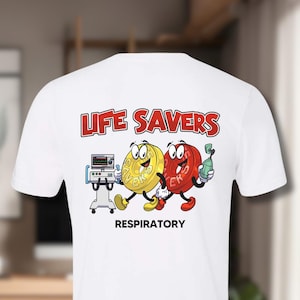 Puede incluir: Camiseta blanca con un diseño de dibujos animados rojo y amarillo de caramelos Life Savers con el texto "Life Savers Respiratory" en la parte posterior. La parte delantera de la camiseta tiene una versión más pequeña del diseño con el texto "Life Savers Respiratory".