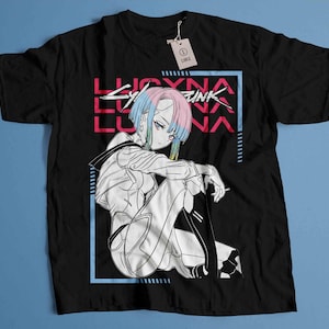 Peut inclure: T-shirt noir avec un graphisme de personnage d'anime aux cheveux bleus et roses, et le texte "LUCYNA CYBERPUNK". Le design est encadr&eacute; dans un rectangle bleu. Une &eacute;tiquette indique "LARGE".