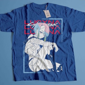 Peut inclure: T-shirt bleu roi avec une illustration de style anime. Le motif pr&eacute;sente un personnage aux cheveux bleus, roses et verts, et le texte "LUCYNA CYBERPUNK" en rouge et blanc. Une &eacute;tiquette indique la taille L.