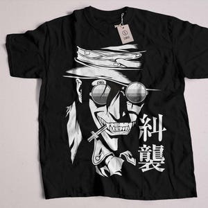 May include: Black t-shirt with a white graphic of a character with a hat, sunglasses, and a cigarette. The text "Alucard" is written in Japanese characters on the shirt.