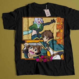 Peut inclure: T-shirt noir avec un imprimé graphique de trois personnages d'anime. Les personnages sont dans un cadre jaune avec le texte "佐 藤 和 真" en japonais. Le texte sous le cadre est "この 素晴らしい 世界 に 祝福 を!"