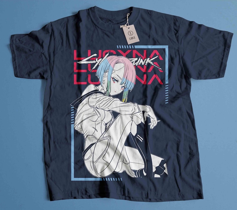 Peut inclure: T-shirt bleu marine avec un graphisme d'un personnage d'anime aux cheveux bleus et roses, et le texte "LUCYNA CYBERPUNK". Le personnage est soulign&eacute; en blanc, avec un cadre bleu et rouge. Une &eacute;tiquette indique "LARGE".