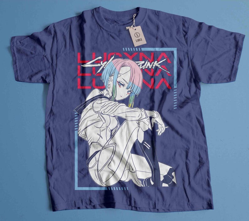 Peut inclure: T-shirt bleu marine avec un dessin d'un personnage d'anime assis aux cheveux bleus et roses, dans un cadre rectangulaire bleu. Le texte "LUCYNA LUNA CYBERPUNK" est imprim&eacute; en rouge. Une &eacute;tiquette indique "LARGE".