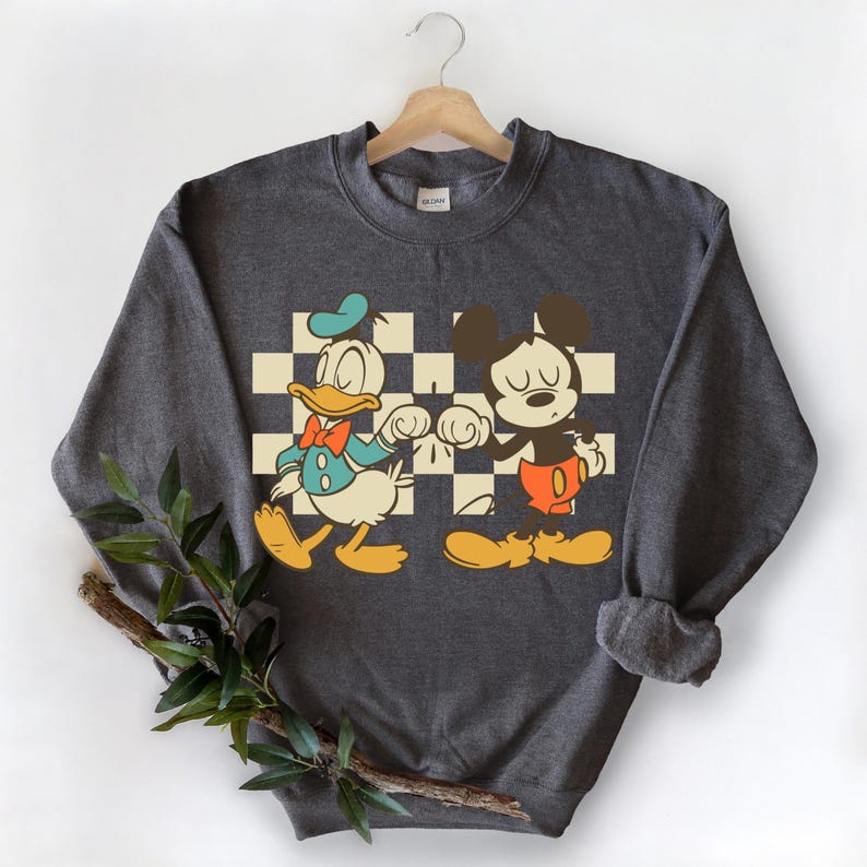 A gray sweatshirt with a graphic design featuring two cartoon characters, Mickey Mouse and Donald Duck, standing together.