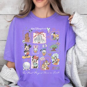 A woman wearing a purple t-shirt with various Disney characters and a castle graphic, along with the text "The Most Magical Place on Earth" and "2026".